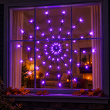 Purple LED spider web light glowing in a front window at night - Lucky Anchor Supplies Co.