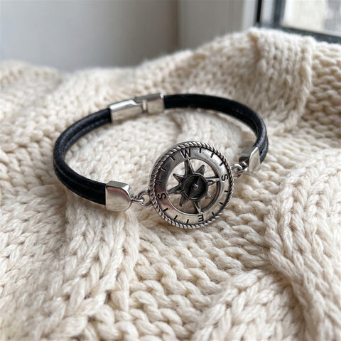 Close-up of a compass bracelet on a knit blanket